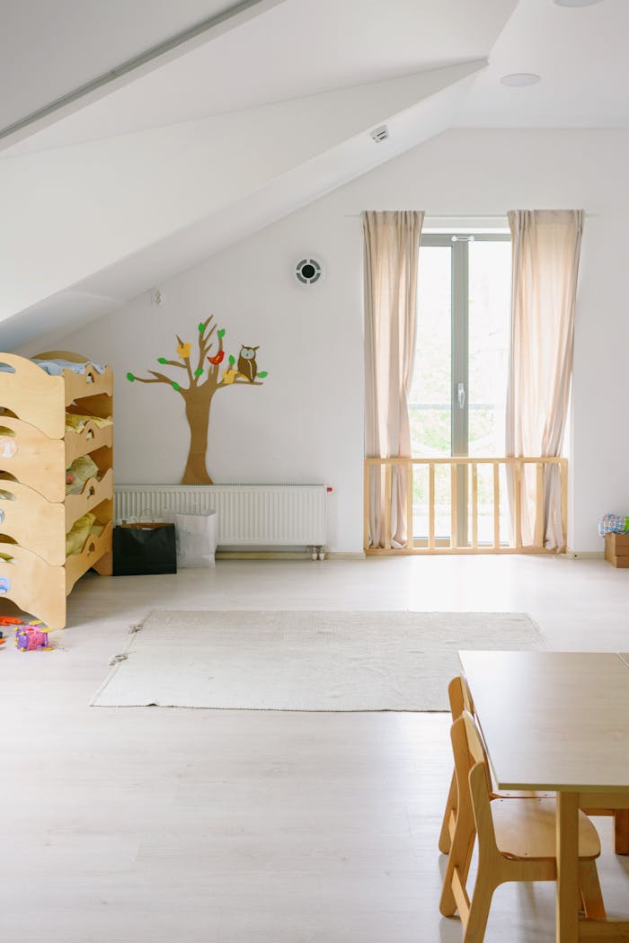 Spacious contemporary childrens room with wooden furniture and pastel tones, ideal for play and relaxation.
